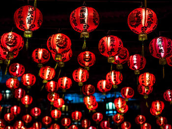 Low angle view of illuminated lanterns hanging at night