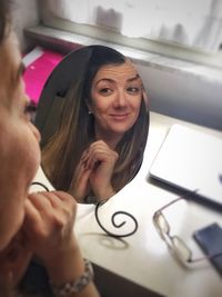 High angle view of woman looking in mirror at home