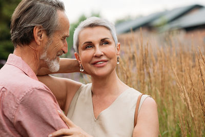 Portrait of smiling friends standing on field