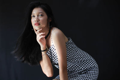 Portrait of a beautiful young woman over black background