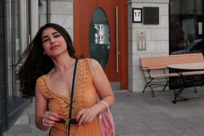 Portrait of beautiful young woman standing against the wall