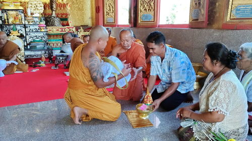 Rear view of people sitting in temple