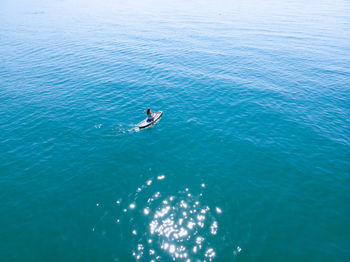 Aerial view of girl sitting on canoe in sea