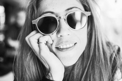 Close-up portrait of happy woman wearing sunglasses