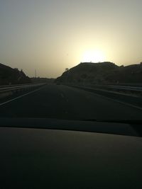 Road against clear sky seen through car windshield