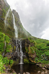 Scenic view of waterfall against sky