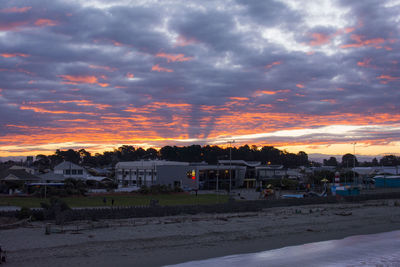 Houses and buildings against dramatic sky during sunset