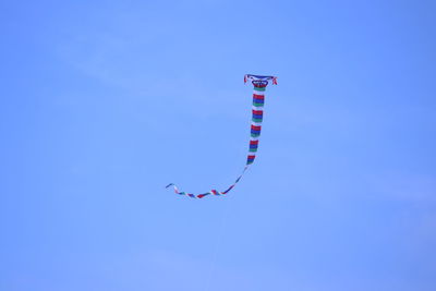 Low angle view of kite flying against clear blue sky