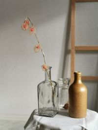 Close-up of glass vase on table against wall