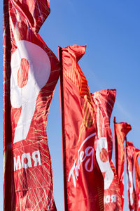 Low angle view of flags hanging against clear sky