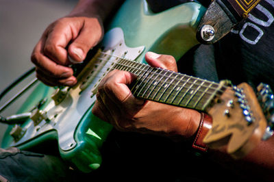 Midsection of street musician playing guitar