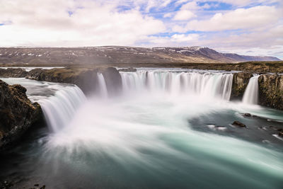 Scenic view of waterfall against sky