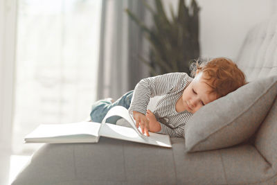 Baby girl  lying on book at home