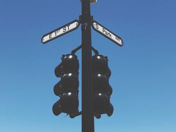 Low angle view of road signal against clear blue sky