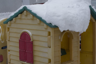 Close-up of snow covered house against building