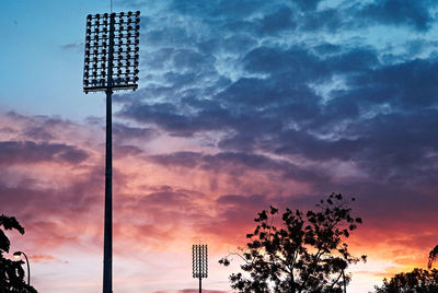 Low angle view of floodlight against sky during sunset