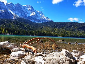 Scenic view of lake by rocks against sky