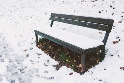 High angle view of snow covered park bench
