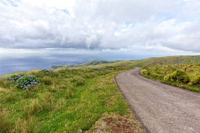 Scenic view of road amidst land against sky