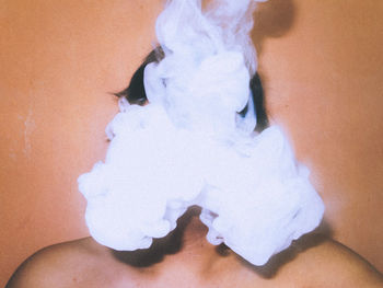 Close-up of shirtless man with face covered in smoke