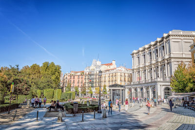 People walking outside teatro real in city