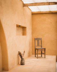 Empty chair and table against wall at home