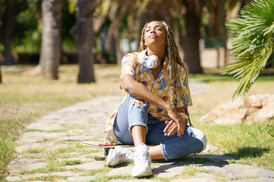 Side view of young woman exercising on field