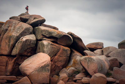 Stack of rocks by sea against sky