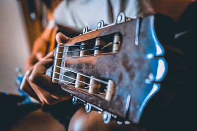 Close-up of person playing guitar at home