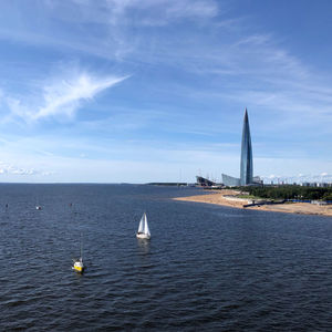 Sailboats sailing in sea against sky