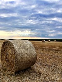 Hay bales on field against sky