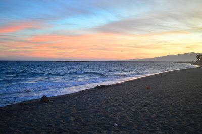 Scenic view of beach against sky during sunset