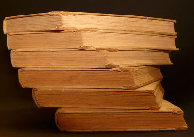 Close-up of books on wood against black background