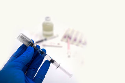 Close-up of hand holding umbrella against white background