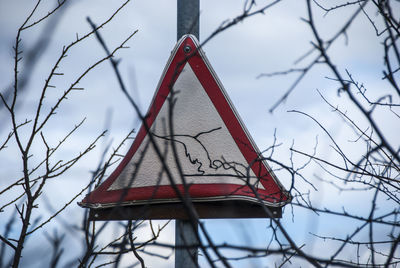 Low angle view of telephone booth against trees during winter