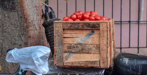 Close-up of fruits in container against wall