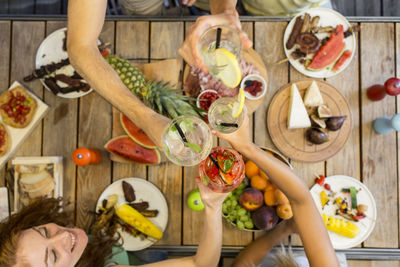 Friends clinking glasses above outdoor table