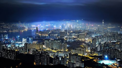 Illuminated cityscape against sky at night