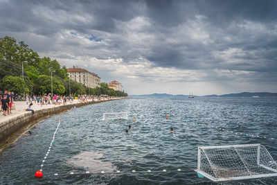 People on sea shore against sky