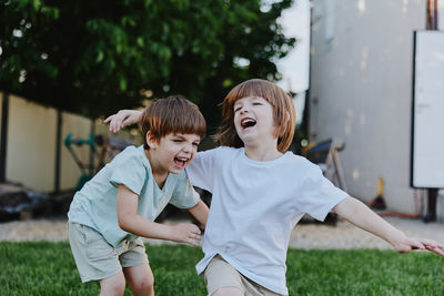 Portrait of siblings playing in park