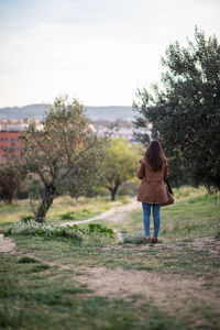 Rear view of woman walking on field