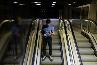 Full length of man standing on escalator