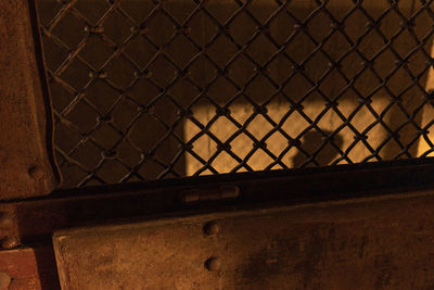 Close-up of chainlink fence against wall