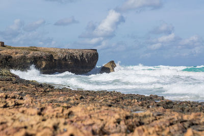 Rocks on beach against sky