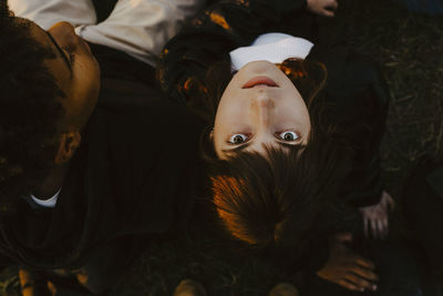 Directly above portrait of woman lying by friend