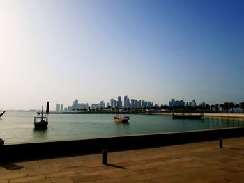 Scenic view of sea and buildings against clear sky