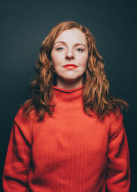Portrait of mid adult woman against black background
