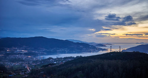 High angle view of buildings and sea against sky at sunset