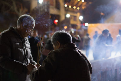 Rear view of people on street at night