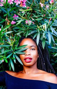 Portrait of young woman standing against plants